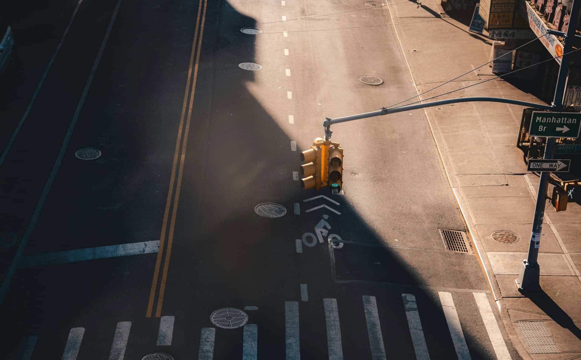 Empty city street with traffic lights and crosswalks at dawn.