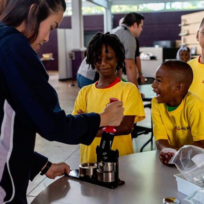 Children engaging in a science experiment with a facilitator at The Cultural Trust.