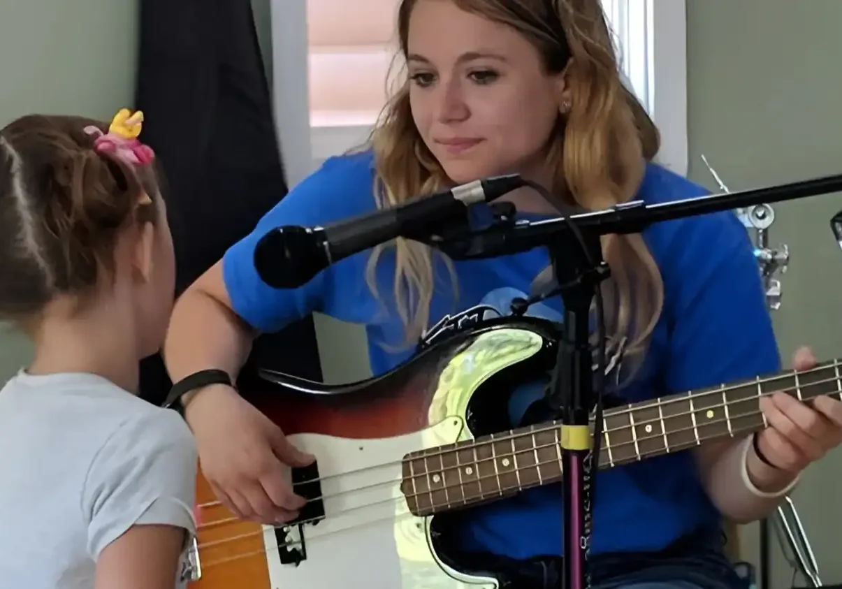 Young girl learning guitar with instructor at The Cultural Trust music program.