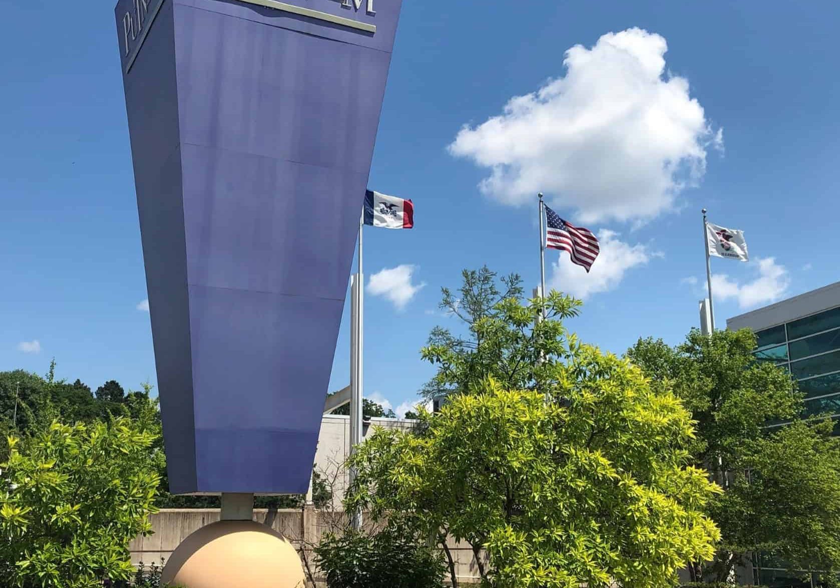 Putnam Museum and Science Center sign in front of lush greenery and flags.