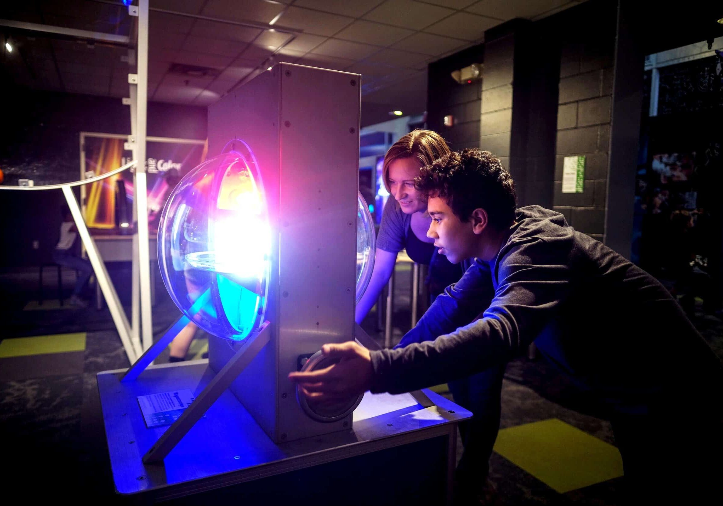 Two young boys engaging with a colorful, illuminated science exhibit at The Cultural Trust.